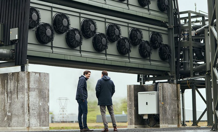 Two men in front of a carbon capture facility